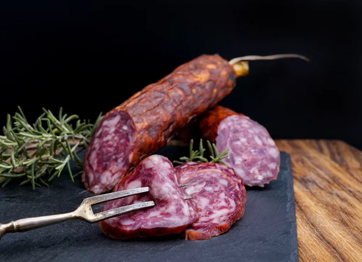 Salame affettato su un tagliere di ardesia